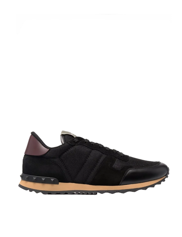 Black sneaker with a brown sole on a white background